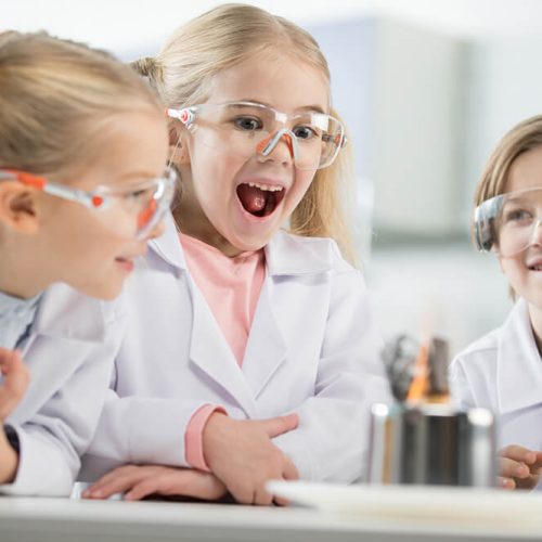 three-kids-wearing-protective-glasses-in-science-l-RTGFW2P