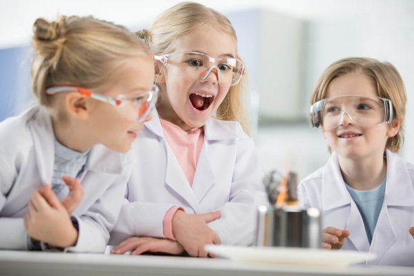 three-kids-wearing-protective-glasses-in-science-l-RTGFW2P